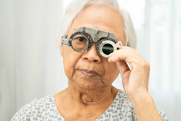 istock Asian senior woman wearing ophthalmic vision eye test and using optical trial frame. 2202017343