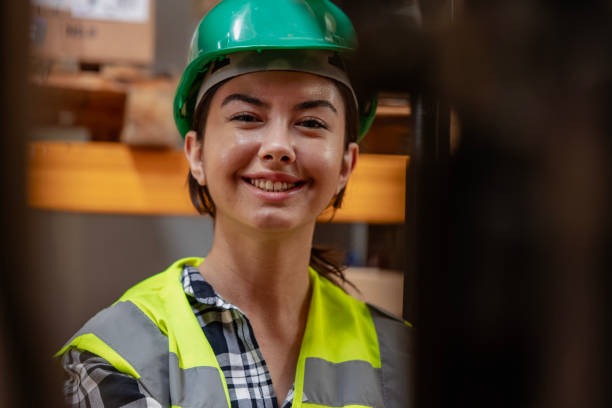 istock Efficient Warehouse Operations: Female Forklift Driver Poses and Drives Worklift at Distribution Warehouse. 2202018486