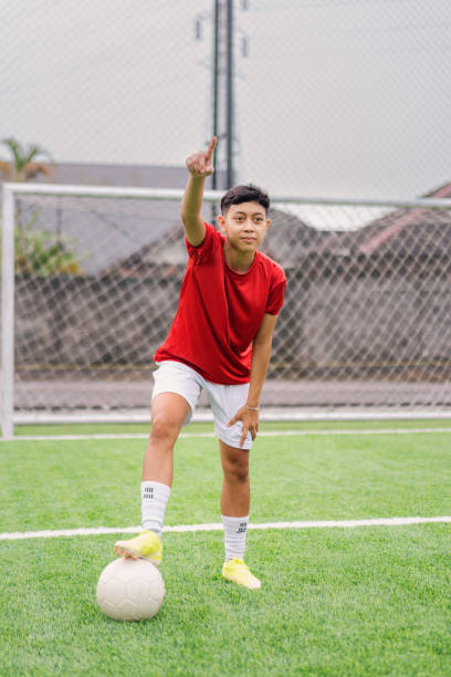 istock Young Female Football Player Pointing Forward During Practice on the Field 2202020901