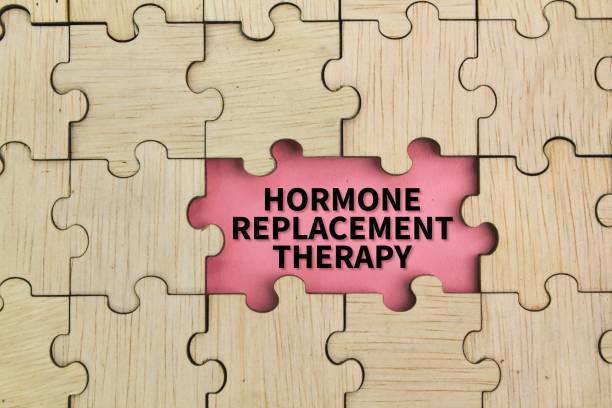 istock wooden puzzle and pink background with the word hormone replacement therapy. 2202021311