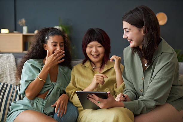 istock Three Girls Enjoying Watching Funny Videos In Internet 2202021641