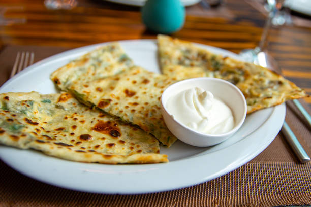 istock Delicious gourmet flat bread kutabs with herbs and cheese on a plate 2202021783