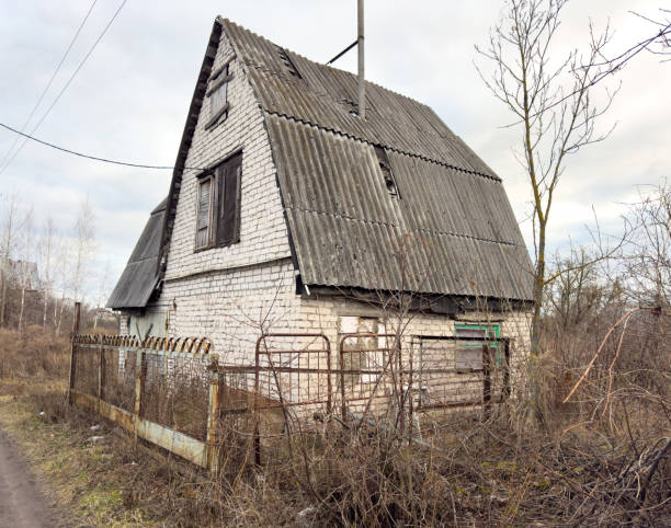 istock A dilapidated old house with a rusted gate and a tree in the background 2202024832