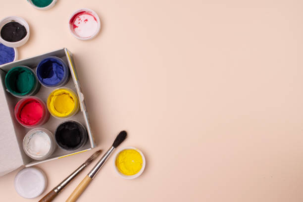 istock jars with gouache paints and brushes on a beige background, painting set, copy space 2202026739