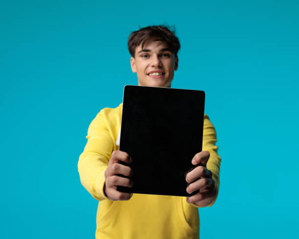 istock happy casual man showing a blank tablet screen 2202027567