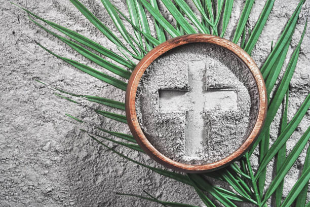 istock Bowl with ashes with cross print and palm branches on ash background. Ash Wednesday 2202028697
