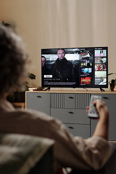 istock Person Watching TV Show On Modern Flat Screen 2202029492
