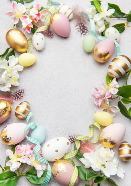 istock Easter eggs frame forming a circle on a gray background with flowers and feathers 2202029677