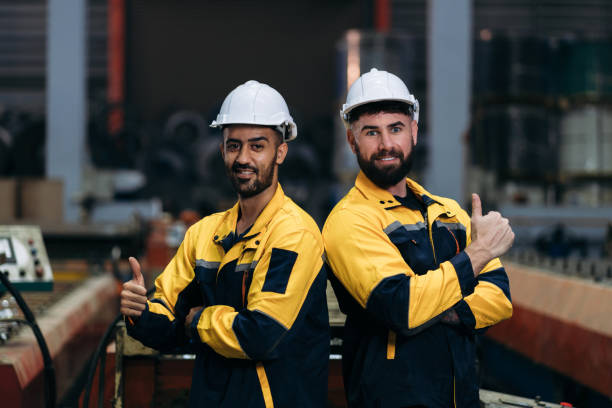 istock Worker inspecting factory machines, a technician working with metal sheets, and a foreman checking materials or equipment. 2202029701