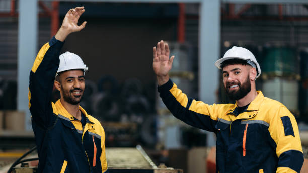 istock Worker inspecting factory machines, a technician working with metal sheets, and a foreman checking materials or equipment. 2202029866