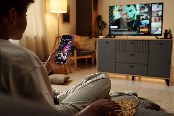 istock Relaxing at Home Watching TV and Checking Phone Notifications 2202030273