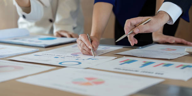 istock Team collaborating on financial reports and charts in a modern office setting. 2202030952