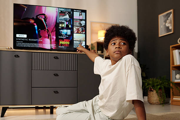 istock Young Boy Watching Television in Living Room Setting 2202031027