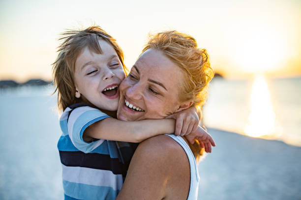istock Loving single mother and son embracing on the beach at sunset. 2202033242