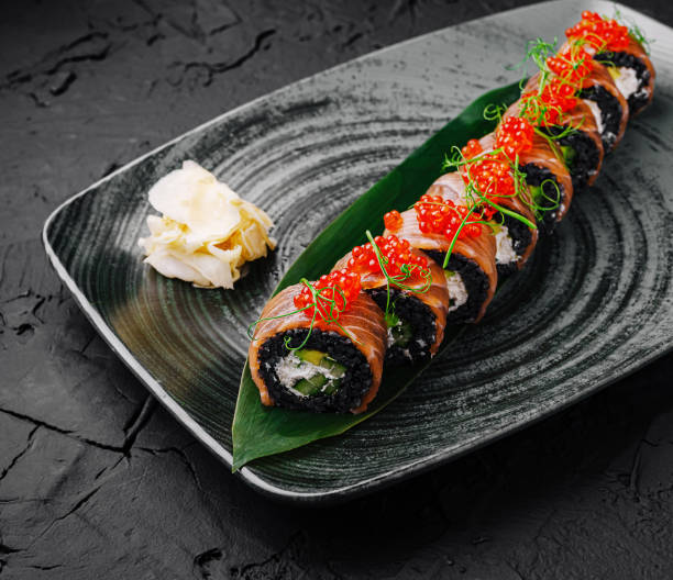 istock Delicious sushi platter presented elegantly on a textured black plate with fresh ingredients and toppings 2202034431