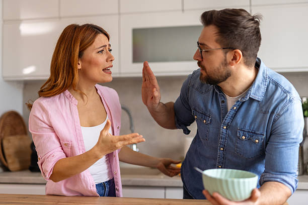 istock domestic dispute unfolds as a woman passionately gestures while speaking, blocking her out with his hand. Atmosphere is filled with tension and frustration, representing relationship struggles 2202036914