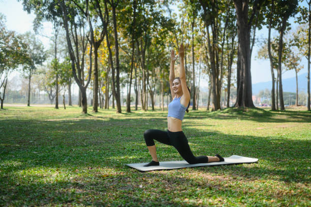 istock Smiling young woman practicing yoga in a peaceful park 2202038037