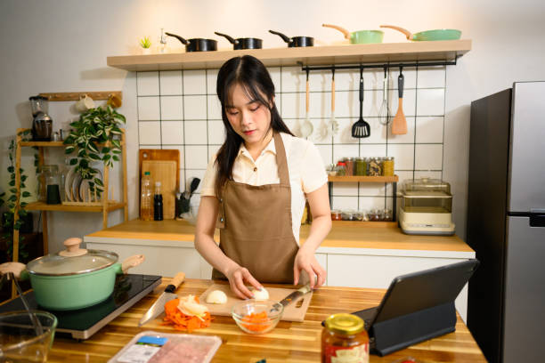istock Smiling woman in an apron preparing ingredients for spaghetti in a cozy kitchen 2202038083