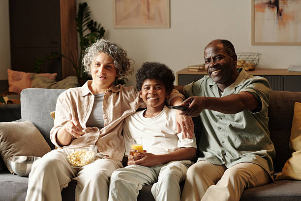 istock Watching TV with Family while Enjoying Snacks on Couch 2202039313