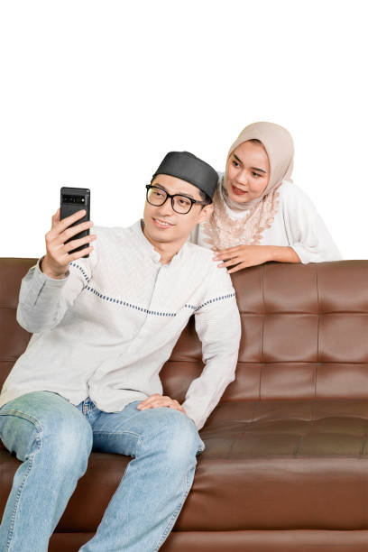 Muslim Couple Taking a Selfie Together on a Sofa