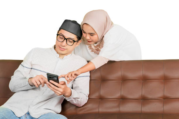 istock Muslim Couple Using Smartphone Together on a Sofa 2202041065