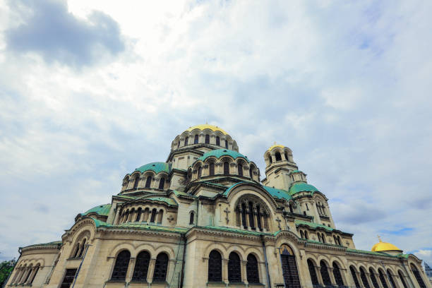 Visitors admire the remarkable architecture of Alexander Nevsky Cathedral in Sofia Bulgaria on an overcast day.