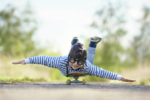 istock cute smiling boy is flying on his skateboard in spring season 2202042245