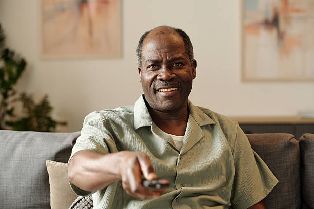 istock Smiling African American Man Holding Remote Control 2202043179