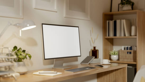 istock A white screen computer on the wooden table with decors. Minimal style study room or home office. 2202043187