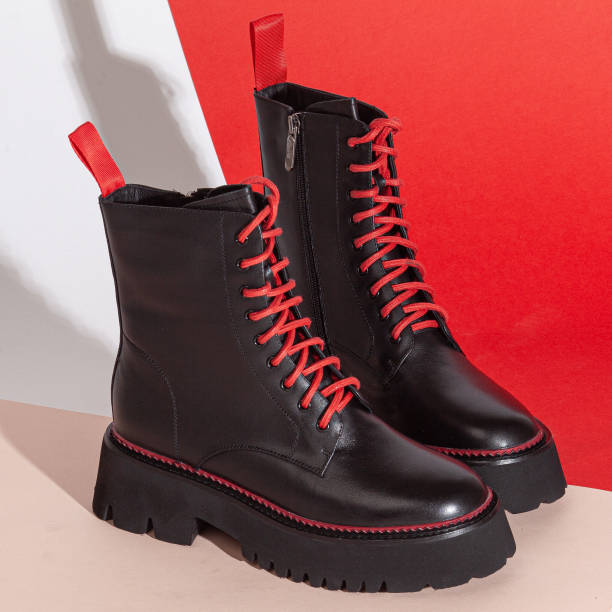 istock Woman's big balck shoes boots with red laces in studio 2202043340