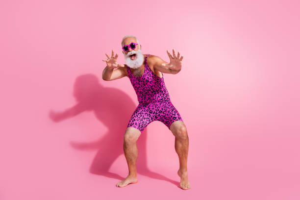 Full size photo of glamour senior man have fun dancing wear leopard print swimsuit isolated pink color background Full size photo of glamour senior man have fun dancing wear leopard print swimsuit isolated pink color background. gay man men sunglasses party stock pictures, royalty-free photos & images