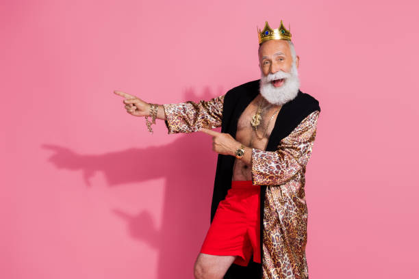 istock Portrait of charismatic actor wear leopard coat crown direct fingers empty space isolated on pink color background 2202044708