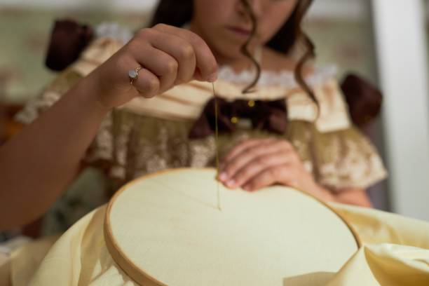istock Elegant Female Hands Threading Needle doing Embroidery 2202045539