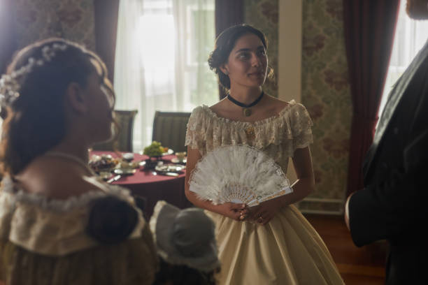 istock Lady Holding Lace Fan in Conversation with Guests 2202045605