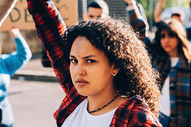 istock Determined young woman at protest raising her fist 2202045780