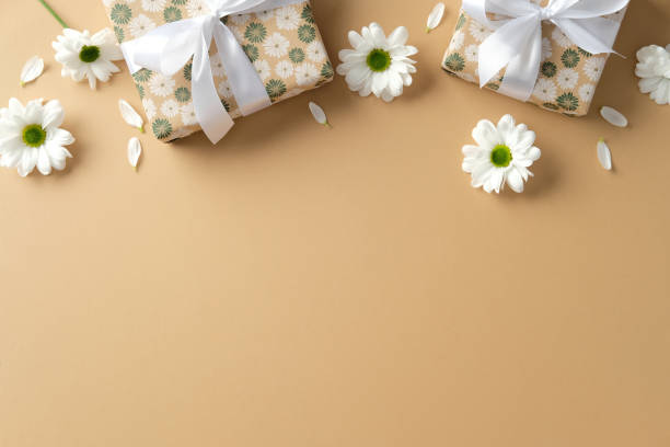 istock Mother's day greeting card mockup. Top view gift boxes with floral pattern and daisy flowers on paste beige background. 2202046601