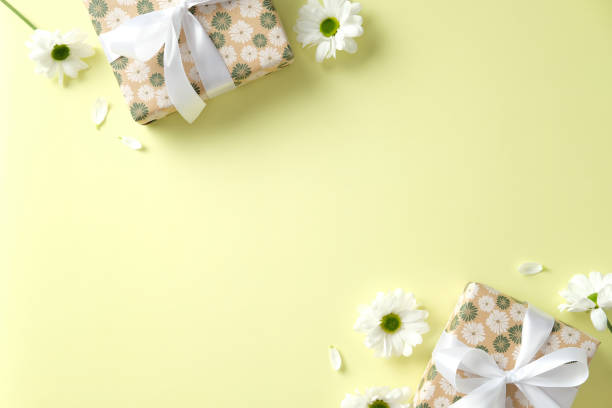 istock Mother's day greeting card template with gift boxes and daisy flowers on pastel green table. Top view. 2202046619