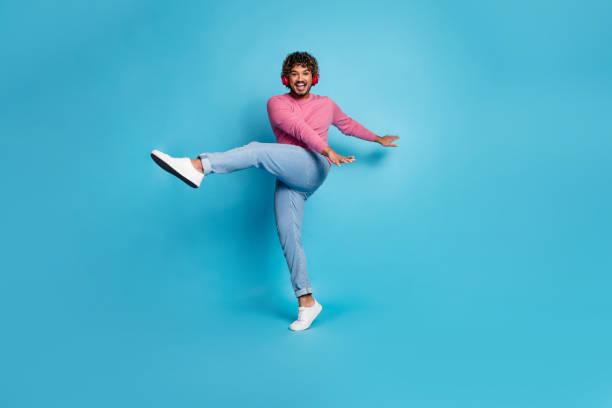 istock Stylish young man in casual outfit posing confidently in vibrant blue studio setting 2202047826