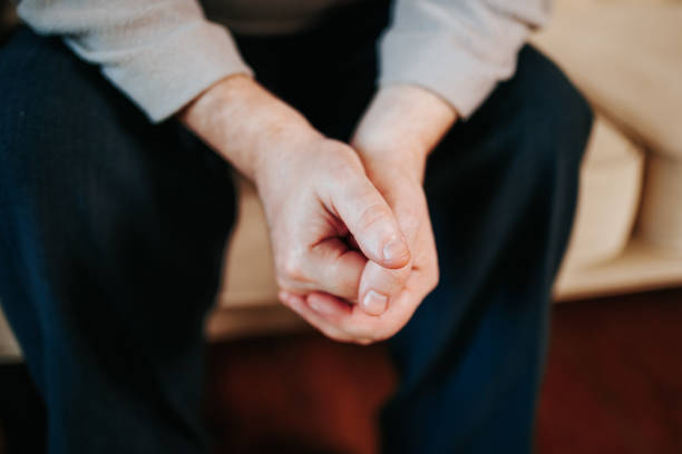 istock Hands resting together while sitting on a couch indoors in a calm setting 2202049780