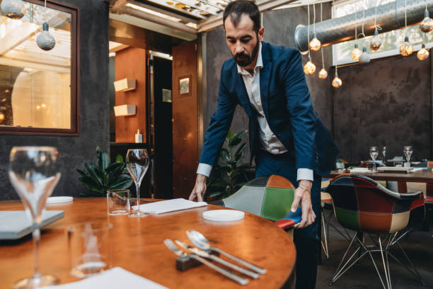 istock A waiter is setting the table before the arrive of the clients 2202051095