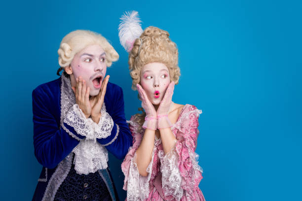 istock Two young individuals in baroque costume express surprise against a vibrant blue backdrop 2202053331