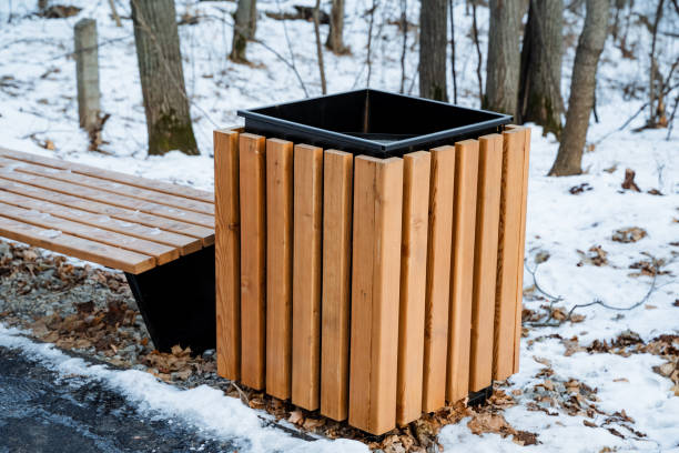 istock A charming wooden trash can is positioned next to a beautifully crafted wooden bench, both elegantly blanketed in pristine white snow, collectively creating a truly picturesque winter scene 2202054640