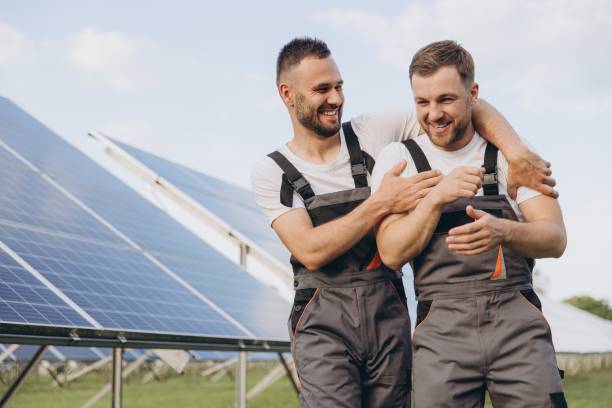 istock Two happy bearded gay in work uniforms joying and flirting with each other hugging on the background of solar panels 2202057003