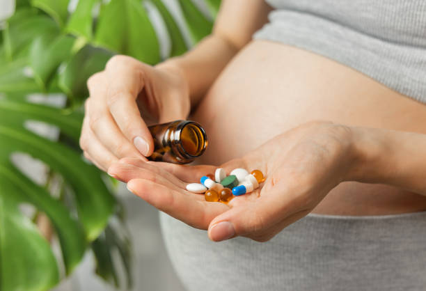 istock pregnant woman with vitamins in hand 2202057199