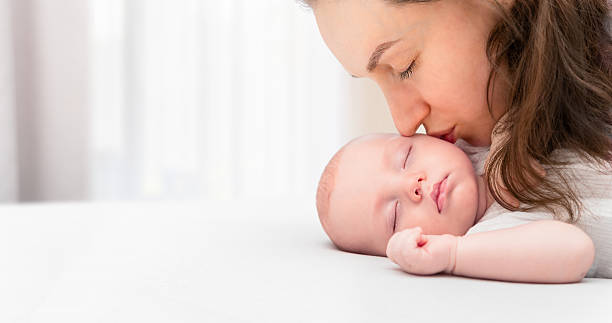 istock Mom kisses baby 2202057468