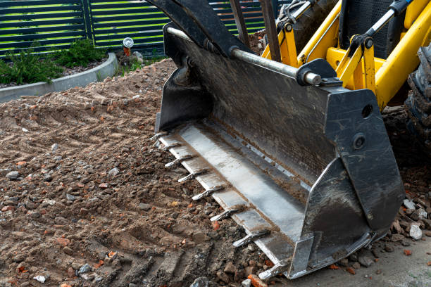 istock A backhoe loader carries and levels rubble on a dirt road. 2202059183