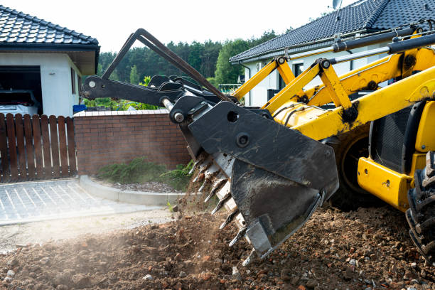 istock A backhoe loader carries and levels rubble on a dirt road. 2202059184