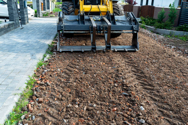istock A backhoe loader carries and levels rubble on a dirt road. 2202059240