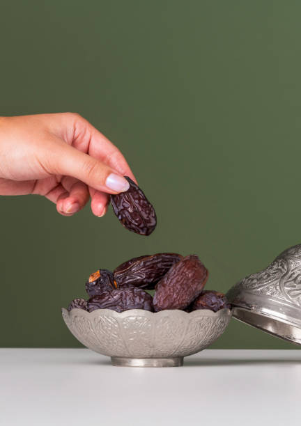 istock Ramadan concept, Date fruit in traditional silver bowl over green background 2202060051