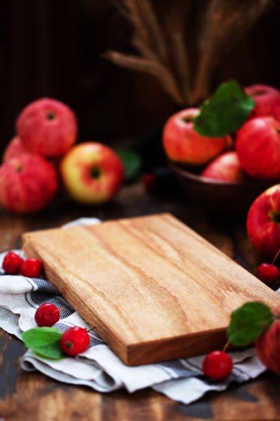 Wooden cutting board with apples around, menu background, copy space